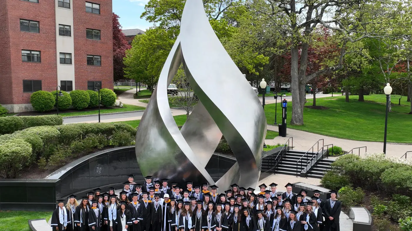 Graduates in front of flame statue
